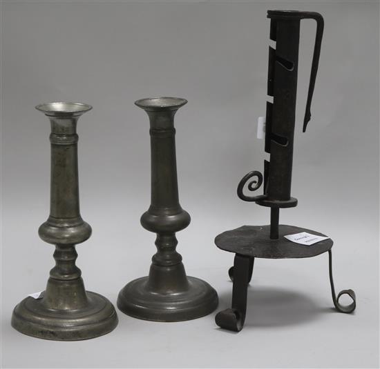 An 18th century French wrought iron adjustable candlestick and a pair of pewter candlesticks